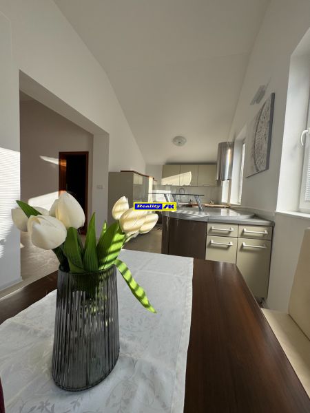 Küche in einem Einfamilienhaus mit einer dekorativen Vase und weißen Blumen auf dem Tisch.