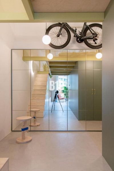 Spiegelwand und Treppe, die in die obere Etage einer 2-Zimmer-Wohnung führen.