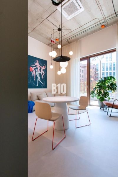 Essbereich in einer 2-Zimmer-Wohnung mit einem Kunstgemälde und Hängelampen.