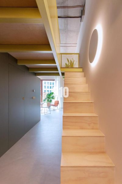 Die Treppe führt in das obere Stockwerk einer 2-Zimmer-Wohnung mit hellem Interieur.