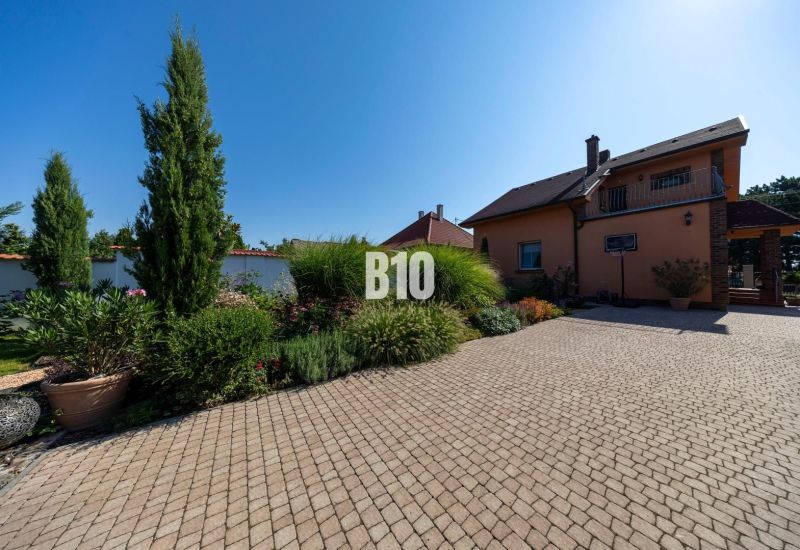 Ein Einfamilienhaus in der Bratislavská-Straße in Malinovo, umgeben von einem gepflegten Garten und Pflastersteinen.