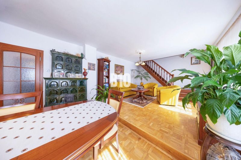 Wohnzimmer in einem Einfamilienhaus mit Holzboden, einem Ofen und einer Holztreppe.