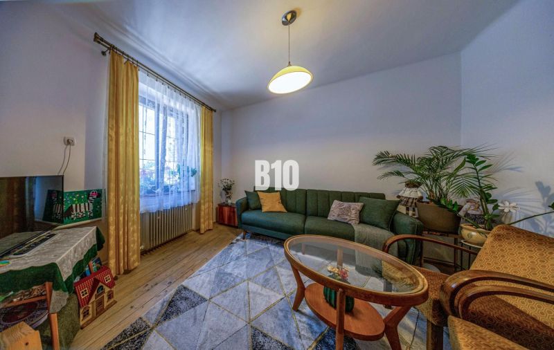 Wohnzimmer in einem Einfamilienhaus mit Sofa, Teppich und Holzboden.