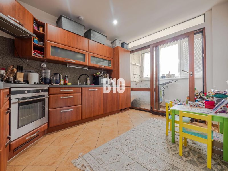 Küche in einer 3-Zimmer-Wohnung mit Holzboden und Balkon.
