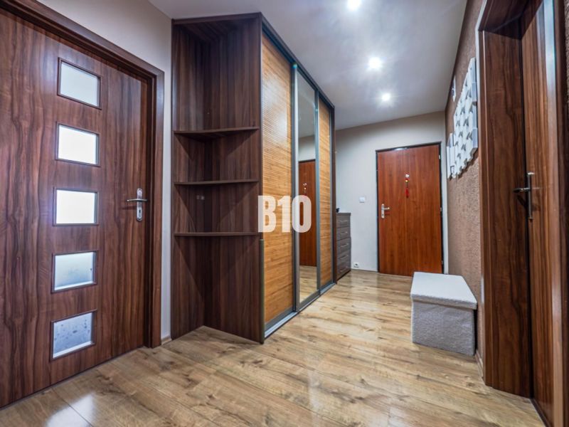 Flur in einer 3-Zimmer-Wohnung mit Holzboden und Einbauschrank.