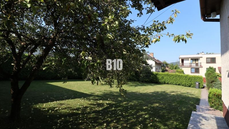 Ein Einfamilienhaus in Žilina mit Garten, Obstbaum und Rasen.