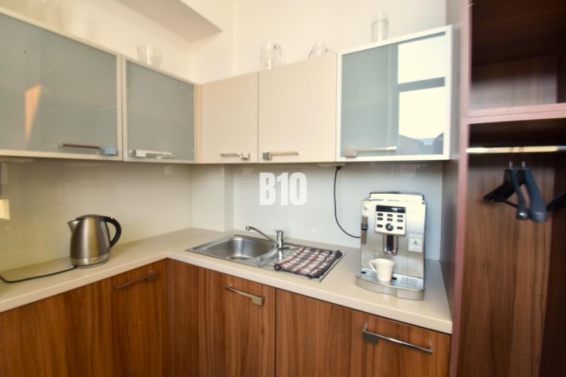 Eine Teeküche mit Kaffeemaschine und Wasserkocher im Büro mit Holzdekor.