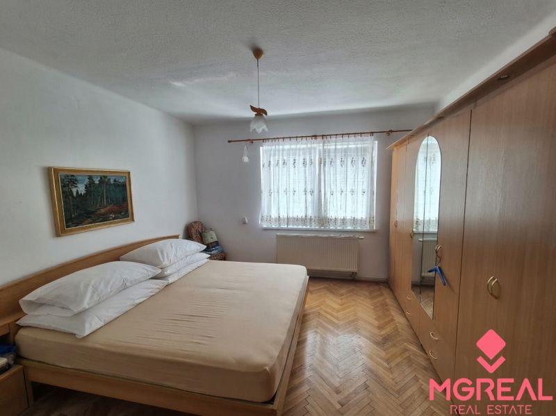 Schlafzimmer in einem Einfamilienhaus mit Holzboden, Schränken und einem Bild.