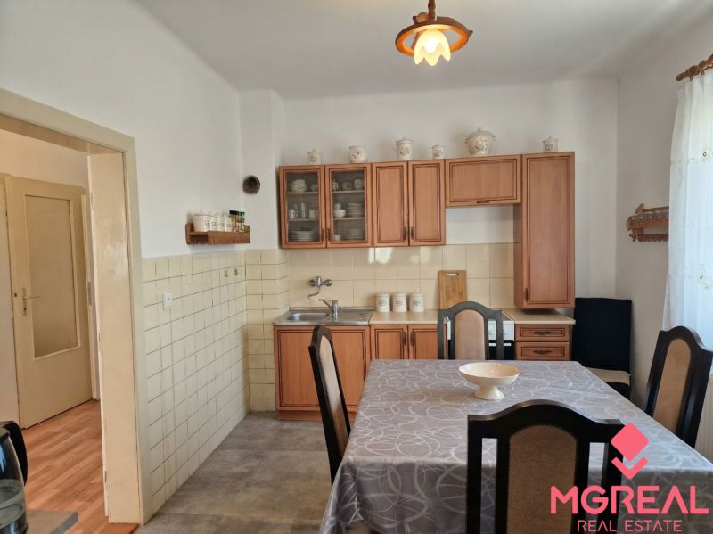 Küche im Einfamilienhaus mit Holzdekor, Esstisch und rustikalen Schränken.