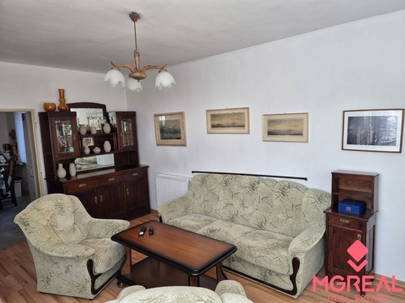 Wohnzimmer eines Einfamilienhauses mit Sesseln, Sofa und Möbelwand.