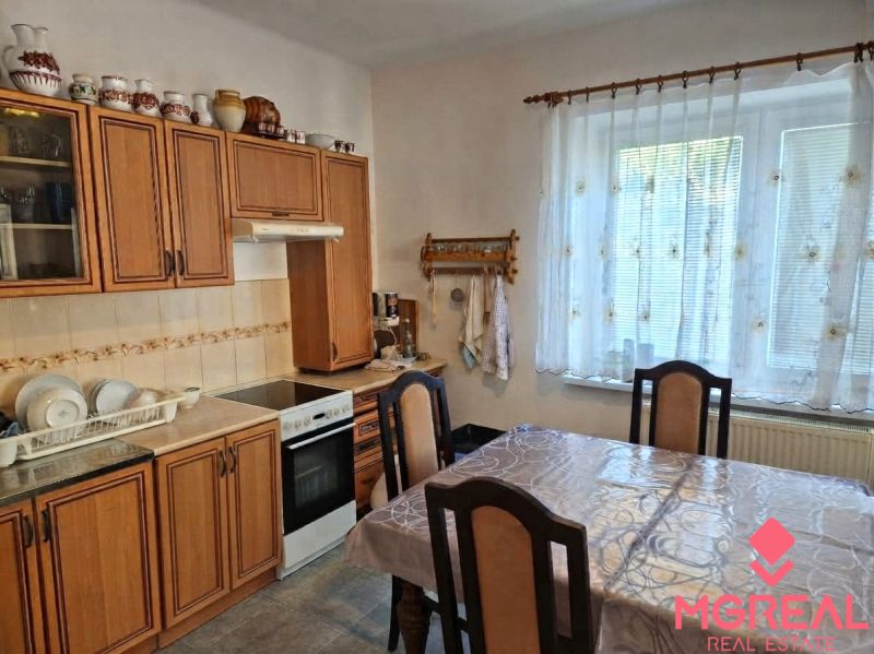 Eine Küche in einem Einfamilienhaus mit Holzdekor, Küchenzeile, Esstisch und Dekorationen.