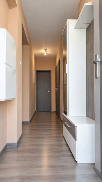 Ein Flur in einem Einfamilienhaus mit einem Holzboden und hellen Wänden.