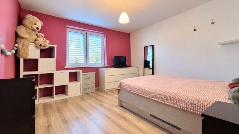 Kinderzimmer mit Kinderbett, Schrank, Spielzeug und Holzboden in einem Einfamilienhaus.
