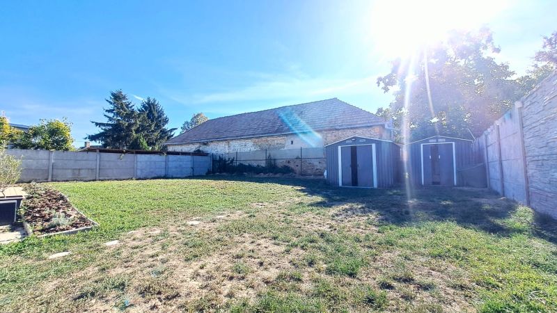 Der Garten eines Einfamilienhauses in Horné Saliby mit Rasen und Blechunterständen.