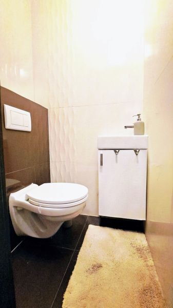Badezimmer in einem Einfamilienhaus mit Toilette, Waschbecken und Relief-Fliesen.
