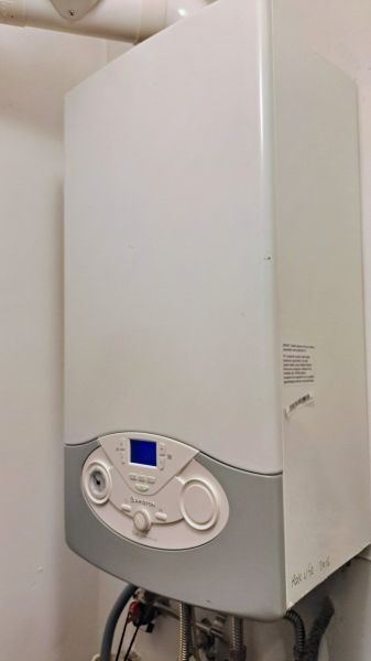Gasheizung im Einfamilienhaus mit digitalem Display und weißem Paneel.