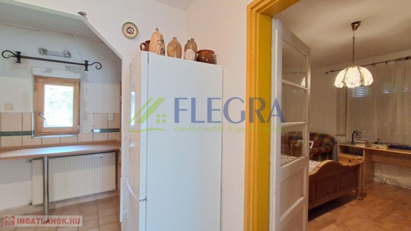 Küche in einem Einfamilienhaus mit Kühlschrank, Ziegeldekor und Holzmöbeln.