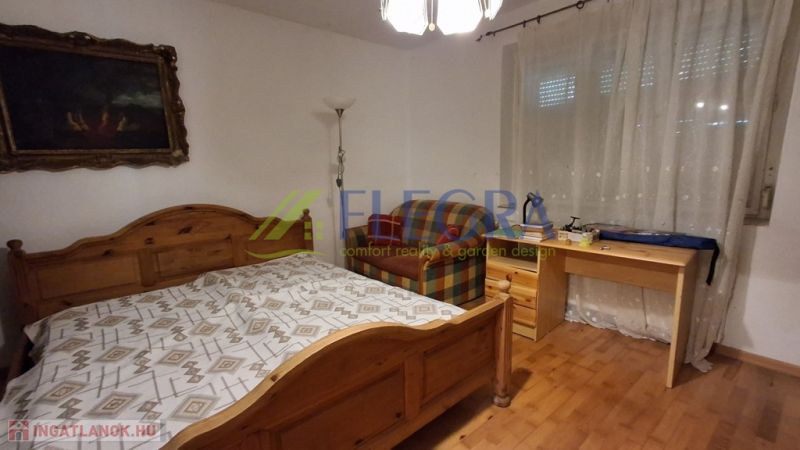 Schlafzimmer in einem Einfamilienhaus mit Holzelementen, Bett und Schreibtisch.