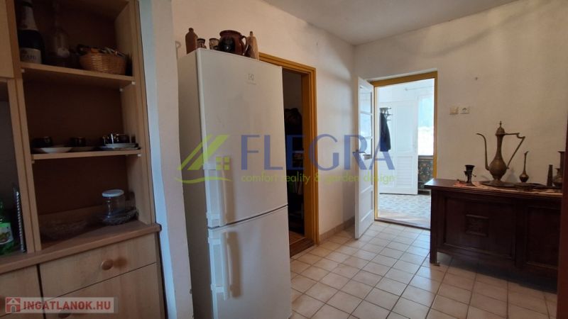 Eine Küche in einem Einfamilienhaus mit einem weißen Kühlschrank und Holzmöbeln.