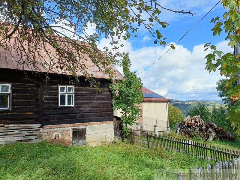 Holzhütte in Staškov mit Obstbäumen und Blick auf die umliegende Landschaft.