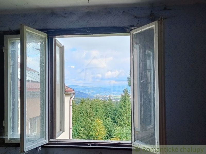 Der Blick von der Hütte auf die Berge und Wälder in Staškov durch das offene Fenster.