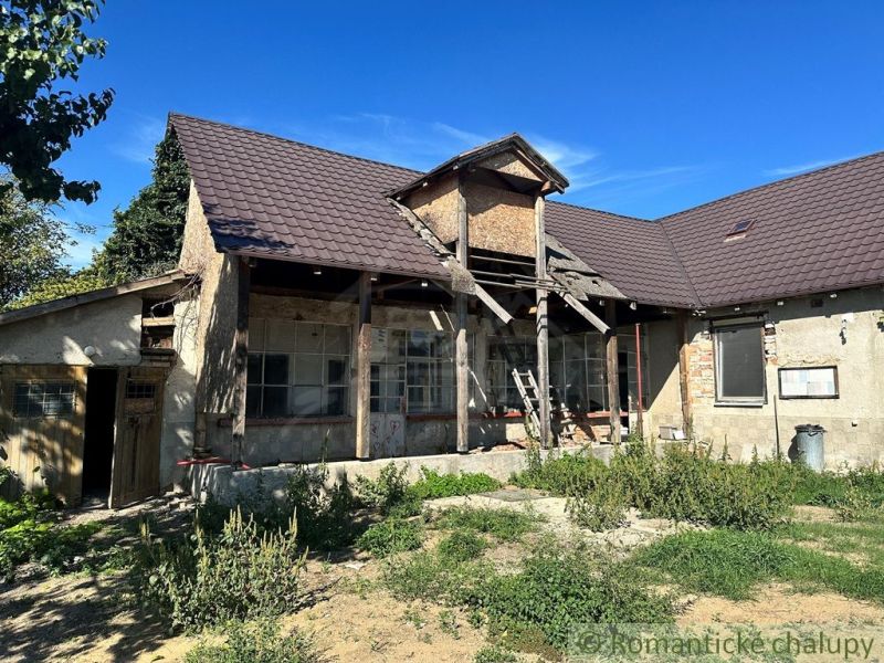 Ein Einfamilienhaus in Vištuk mit einem markanten Dach, umgeben von Grün und blauem Himmel.