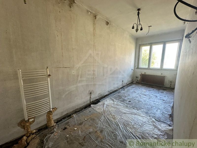Leerer Raum mit Kunststofffenster und freiliegenden Heizkörpern in einem Einfamilienhaus.