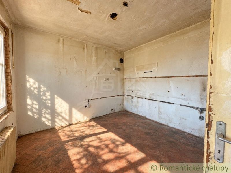 Ein verlassenes Zimmer in einem Einfamilienhaus mit einem Boden in Ziegeldekor.