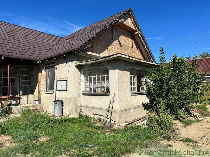 Ein Einfamilienhaus in Vištuk mit einfachen Fassadendetails und einem grasbewachsenen Grundstück.