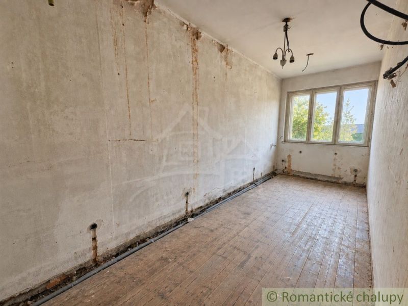 Ein Raum mit unfertigen Wänden und einem Boden in Holzoptik in einem Einfamilienhaus.