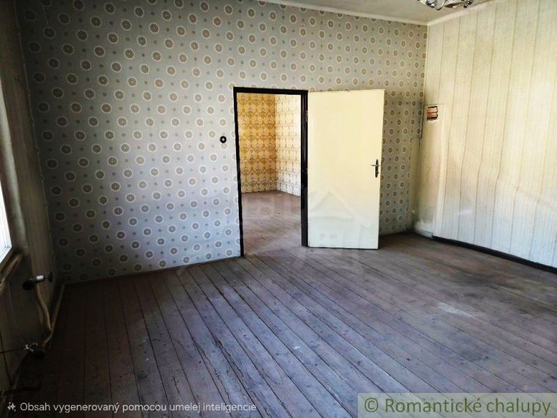 Ein Raum mit Tapeten und einem Boden in Holzoptik, im Hintergrund ein weiteres Zimmer.
