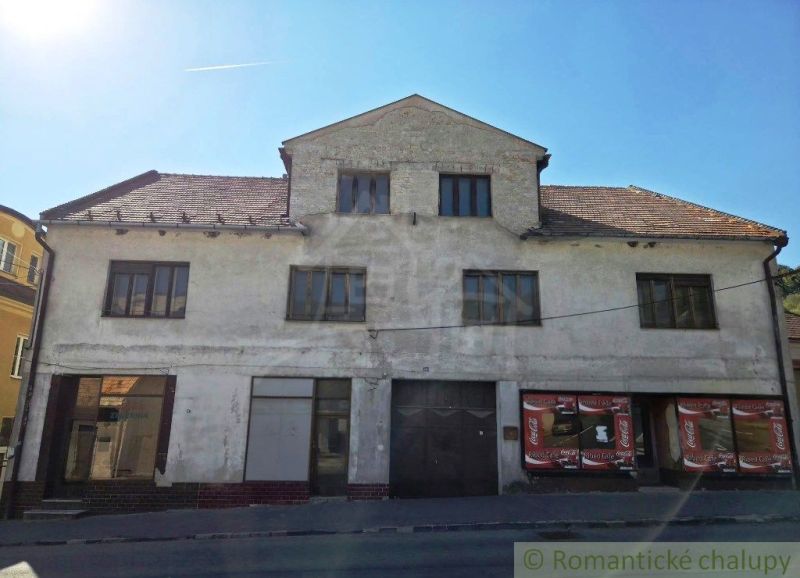 Geschäftsräume in Modrý Kameň mit abgenutzter Fassade und Schrägdach.
