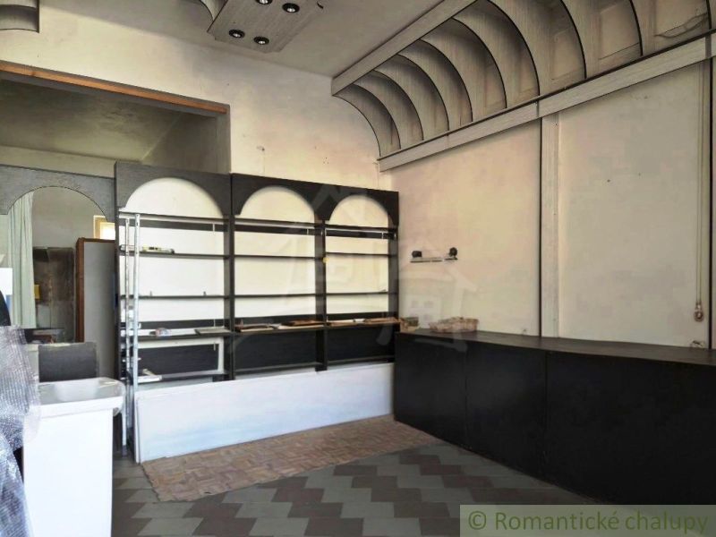 Innenraum mit Theke, Regalen und Boden in Holzoptik.