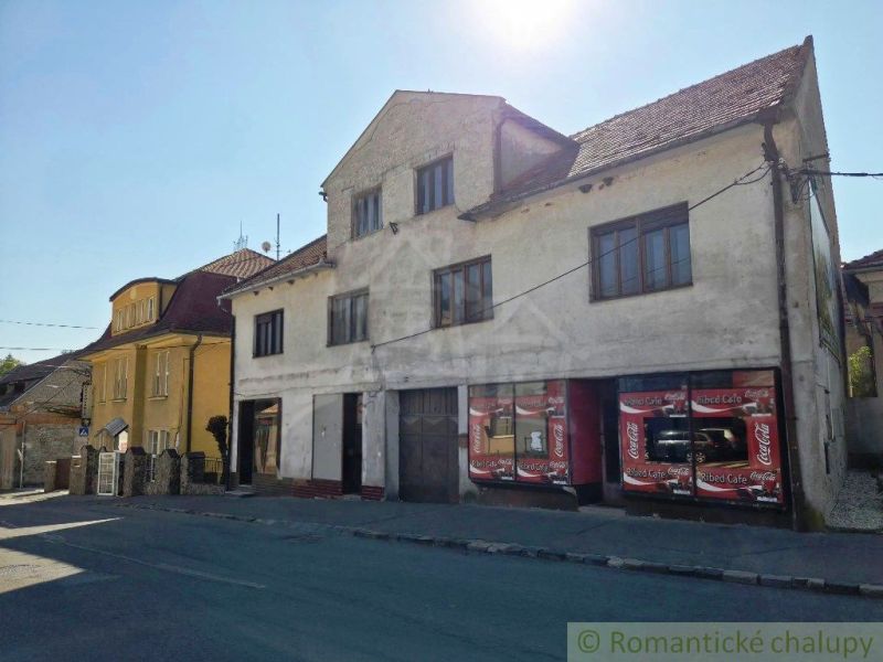 Ein Gebäude mit Geschäftsräumen in der Stadt Modrý Kameň, sichtbar über die Straße.