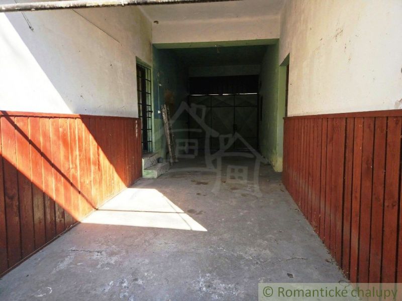 Garage in den Geschäftsräumen von Modrý Kameň mit Wänden aus Holzverkleidung.
