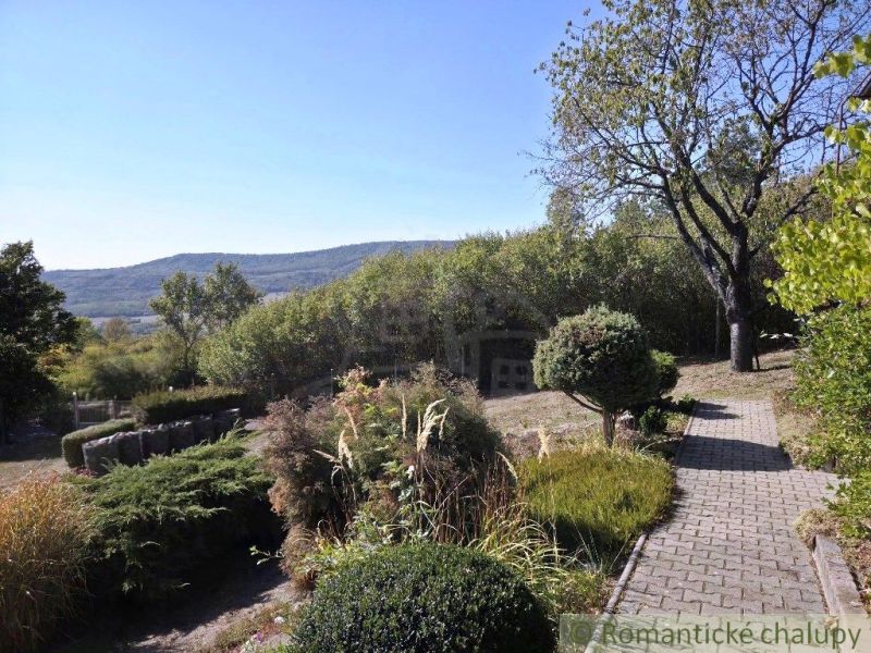 Eine Hütte in Modrý Kameň mit einem gepflegten Garten und Blick auf die hügelige Landschaft.