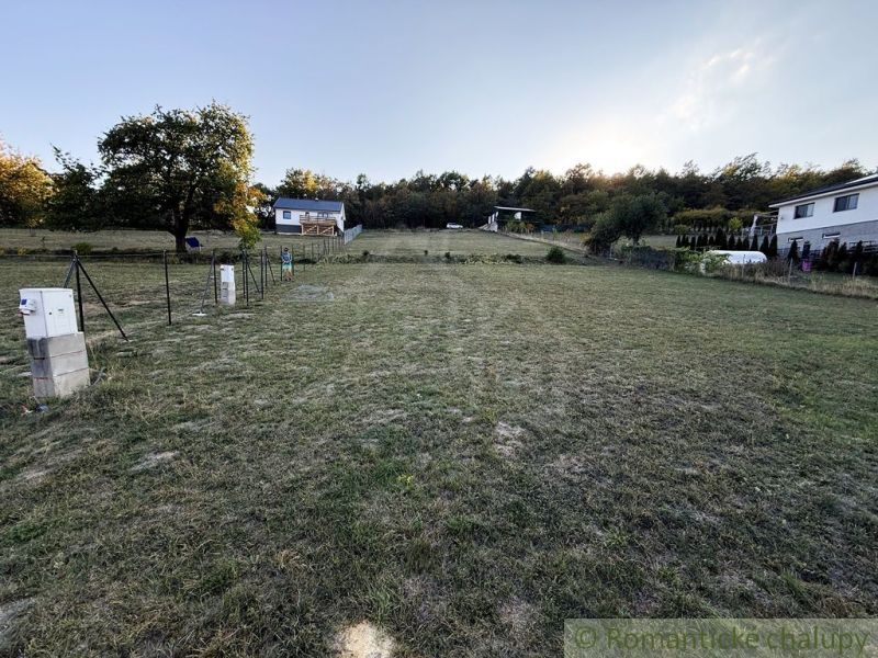 Gärten in Krupina, Häuser am Hang, Gras und Bäume, man sieht einen Verteilerkasten.