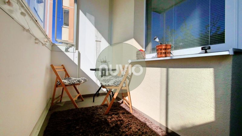 Balkon mit zwei Klappstühlen und einem Teppich in einer 2-Zimmer-Wohnung.