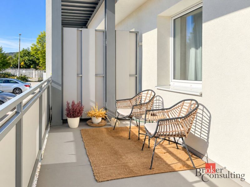 Ein Balkon in der Alexandra-Matušku-Straße in Banská Bystrica mit Rattanstühlen und Teppich.